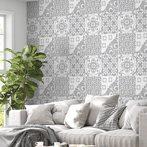 May include: A gray and white patterned wallpaper with a geometric design. The wallpaper is in a living room setting with a gray couch and a green plant.