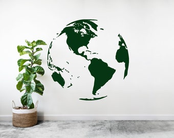 May include: A green globe decal on a white wall with a potted plant in a woven basket.