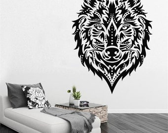 May include: Black and white patterned wolf head wall decal. The wolf's head is stylized with intricate floral designs. The decal is shown on a white wall in a living room setting.
