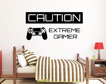 May include: Black and white wall decal with the text "CAUTION EXTREME GAMER" and a silhouette of a video game controller.
