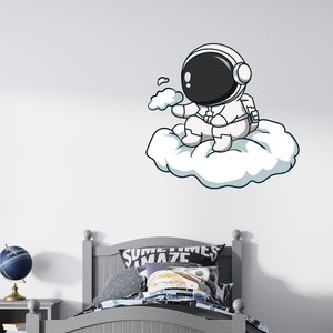 May include: A cartoon astronaut wearing a white spacesuit and a black helmet sits on a white cloud. The astronaut is holding a small white cloud in its hand. The image is on a white background.
