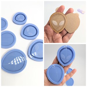 May include: A set of six blue silicone molds shaped like alien heads with two eyes each. The molds are used for making resin crafts.