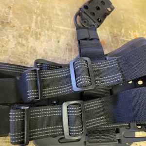 May include: Black tactical belt with two adjustable straps and a black plastic holster with a loop on top.