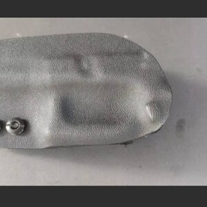 May include: A black leather holster with two silver rivets.