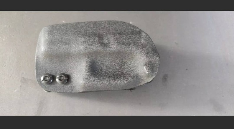 May include: A black leather holster with two silver rivets.