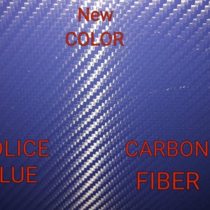 May include: A close-up of a blue carbon fiber material. The text "New Color" is written in red above the material. The text "Police Blue" is written in red below the material on the left. The text "Carbon Fiber" is written in red below the material on the right.