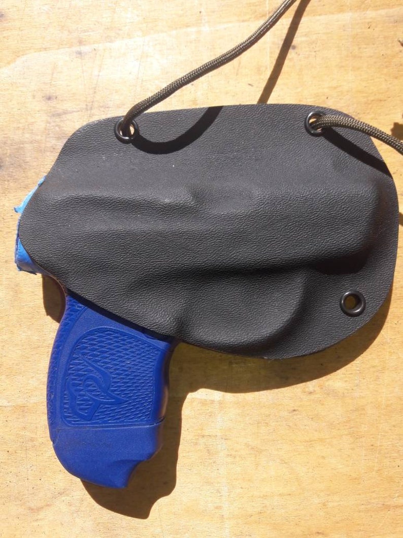 Peut inclure: Un &eacute;tui en cuir noir avec un pistolet bleu et noir &agrave; l'int&eacute;rieur. L'&eacute;tui est dot&eacute; d'une fermeture &agrave; cordon et est con&ccedil;u pour &ecirc;tre port&eacute; sur la hanche.