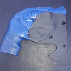 May include: A blue handgun with a black holster. The holster has a hook on the bottom.