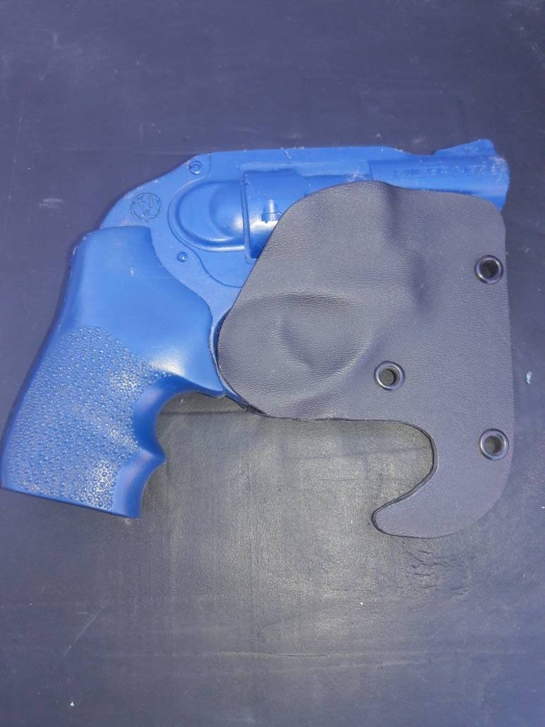 May include: A blue handgun with a black holster. The holster has a hook on the bottom.