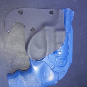 May include: A blue handgun with a black leather holster. The holster has a hook on the top and multiple holes for attaching to a belt.