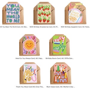May include: A collection of colorful greeting cards in brown envelopes. The cards feature various designs, including strawberries, spaghetti, a sun, and the phrases "You Mean The World To Me," "Happy Birthday," and "Thank You."