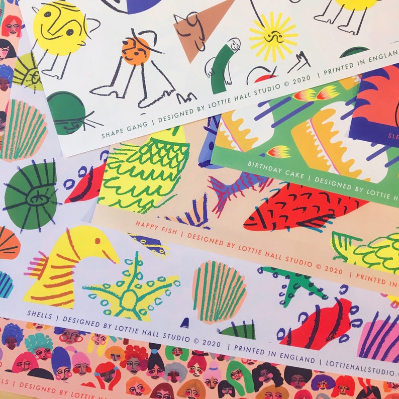 May include: A collection of colorful art prints featuring whimsical illustrations. Designs include fish, shells, and abstract shapes in vibrant hues. Text on the prints reads "SHAPE GANG", "BIRTHDAY CAKE", "HAPPY FISH", and "SHELLS", all designed by Lottie Hall Studio.