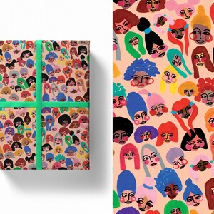 Puede incluir: Papel de regalo con un patrón repetido de caras ilustradas con varios peinados y tonos de piel sobre un fondo melocotón. El regalo envuelto está atado con una cinta verde brillante. El diseño es colorido y caprichoso.