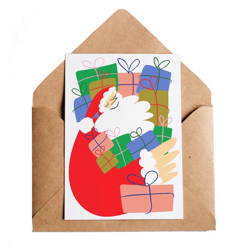 Puede incluir: Tarjeta de Navidad con una ilustraci&oacute;n de Pap&aacute; Noel llevando un saco lleno de regalos coloridos. La tarjeta blanca est&aacute; dentro de un sobre marr&oacute;n. Los regalos son verdes, azules, rosas y rojos.