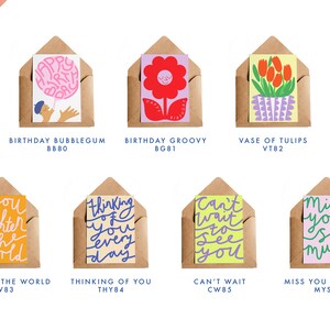 May include: A collection of greeting cards in kraft paper envelopes. The cards feature colorful illustrations and handwritten text, including phrases like "Happy Birthday," "Thinking of You," and "Miss You So Much." The word "NEW!" is in the upper left corner.