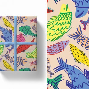 May include: Gift-wrapped package with a colorful fish pattern. The design features hand-drawn fish in shades of yellow, green, red, blue, and purple on a beige background. A light blue ribbon secures the package, creating a cheerful and artistic presentation.