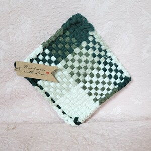 May include: A green and white woven pot holder with a brown tag that says "Handmade with Love".