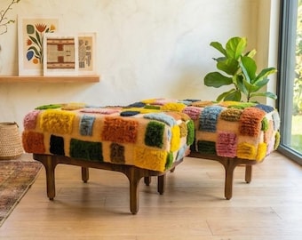 May include: Two rectangular ottomans featuring a multi-colored, tufted, patchwork-style fabric top in shades of yellow, orange, blue, green, and pink, supported by dark brown wooden legs with a curved, mid-century inspired design.