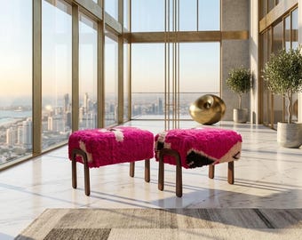May include: Two rectangular ottomans featuring a vibrant, shaggy, hot pink textile top with abstract black and white geometric patterns. Each ottoman is supported by four dark brown wooden legs with a curved, U-shaped design at the base.