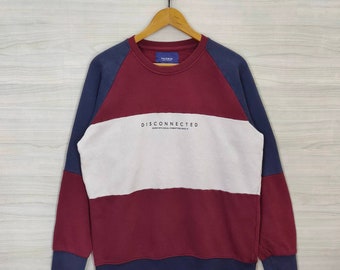 May include: A maroon, white, and navy blue sweatshirt with long sleeves and a crew neck. The sweatshirt has a horizontal color block design and the text "DISCONNECTED" printed on the front.