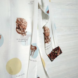 May include: White long-sleeved shirt with a print of various animals and text. The text includes "With Thy wound of grace That enlaved me" and "To take me as thy". The shirt has a leopard print cuff.