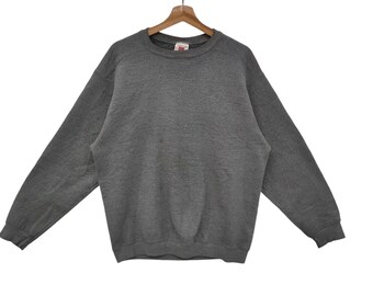 May include: A gray sweatshirt with a crew neck and long sleeves.
