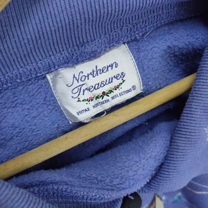 May include: A purple sweatshirt with a white tag that reads "Northern Treasures" and "By PAR Northern Reflections".