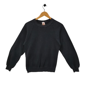 Op de afbeelding: Een zwart longsleeve sweatshirt met een ronde hals en raglanmouwen.