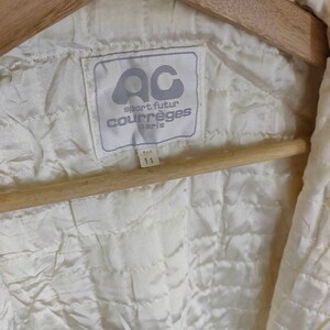 May include: White label with the text "sport futur courr&egrave;ges Paris" and the logo "ac" in a circle. The label has a size tag that says "11" in black text.