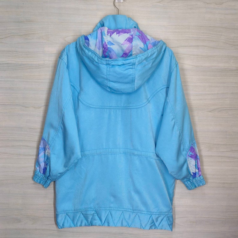 May include: A light blue hooded jacket with a floral print lining. The jacket has a zipper closure and two pockets.
