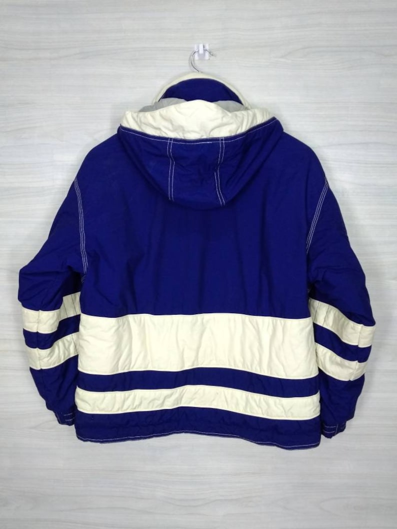 May include: A blue and white hooded jacket with a striped pattern. The jacket has a zip fastening and a drawstring hood.
