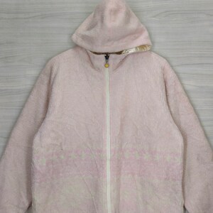 May include: A pink fleece zip-up jacket with a hood. The jacket has a white zipper and a white pattern on the front.