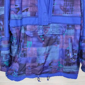 Puede incluir: Una chaqueta de color azul y morado con estampado, con cremallera y capucha con cord&oacute;n. La chaqueta tiene un bolsillo grande en la parte delantera y un bolsillo m&aacute;s peque&ntilde;o en la manga izquierda.