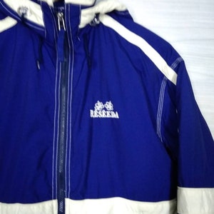 May include: A blue and white hooded jacket with a white stripe down the sleeve and the word "RESEEDA" embroidered on the front.