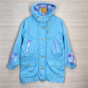 May include: A light blue hooded jacket with a floral print lining. The jacket has a gold zipper and buttons. The brand name "Sport-Vogue" is printed on the bottom left side of the jacket.
