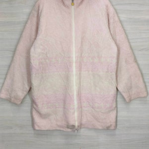 May include: A pink fleece jacket with a white zipper and a subtle white and pink pattern.