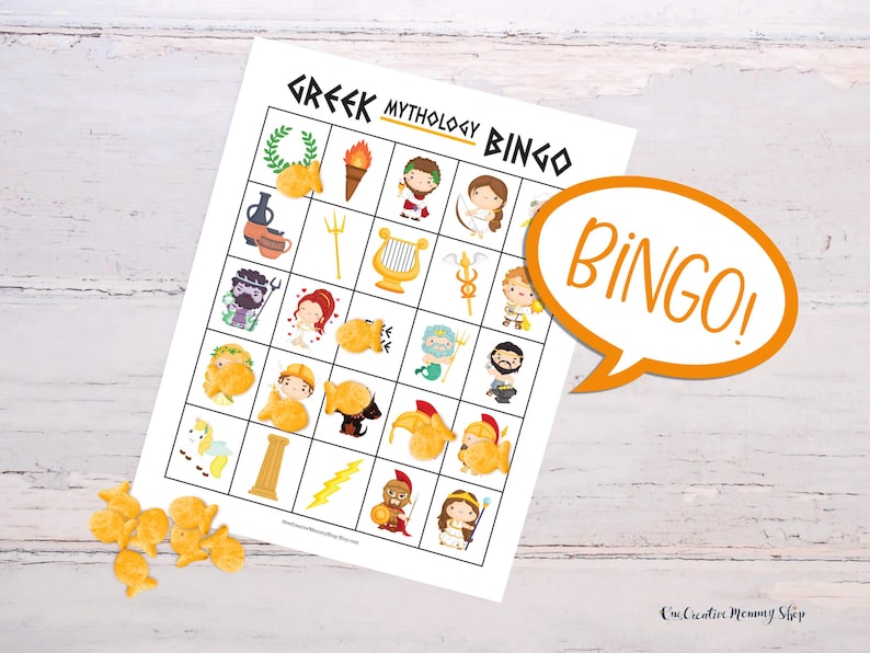 A Greek mythology bingo card is displayed on a wooden table. A pile of gold fish crackers sits next to the board with several pieces covering images on the board. Because five images across the board are covered, a word bubble reads, Bingo!