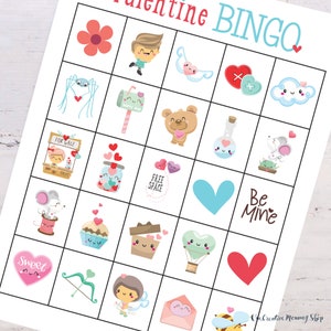 Zoomed in view of a cute Valentines Day bingo card lying on top of a white wooden table. Images on the card include flowers, hearts, cupid, a cute mouse, a mailbox, etc.