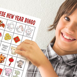 Boy proudly holding up a Lunar New Year bingo card