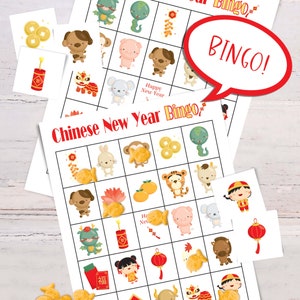 2 Lunar New Year bingo cards lying on a white table. Six calling cards are scattered across the game, and several spots are marked with goldfish crackers. A word bubble says Bingo!