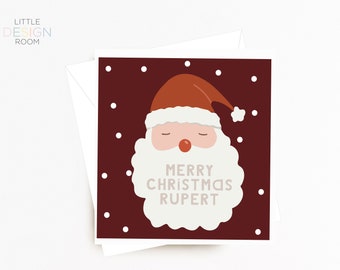 May include: A red and white Christmas card featuring a cartoon Santa Claus face and the text "Merry Christmas Rupert".