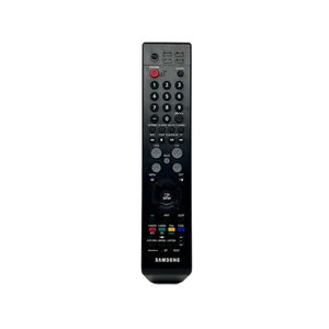 Op de afbeelding: Een zwarte Samsung tv-afstandsbediening met tal van knoppen, waaronder aan/uit, volume en kanaalbediening. De afstandsbediening heeft een rode aan/uit-knop en een rond navigatiepad. De merknaam "SAMSUNG" staat onderaan.