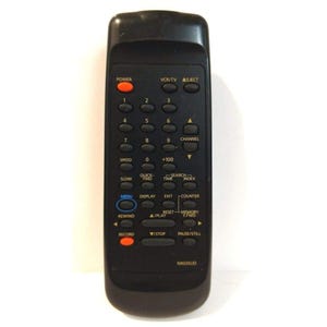 May include: Black remote control with multiple buttons for a VCR or TV. Features buttons for power, channel selection, and playback controls. The model number N903SUD is printed at the bottom.