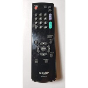 May include: Black Sharp LCDTV remote control with numerous buttons, including power, volume, channel, and number keys. The remote has the brand name "SHARP" and model "GA566WJSA" printed on it.