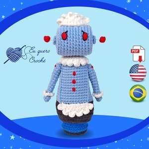 May include: A crocheted robot doll with a blue body, white collar, and red buttons. The robot has a white hat and red eyes. The doll is standing on a blue base. The image includes the text "Eu quero Crochê" and a PDF download icon.