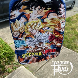 May include: A blue backpack featuring a vibrant graphic print of various Dragon Ball Z characters in different forms, including Super Saiyan variations. The name STEVON URIAH is printed in bold yellow and red letters across the lower section of the bag.
