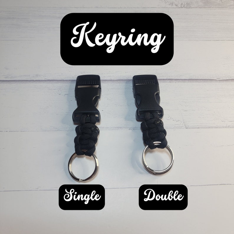 May include: Two black paracord keyrings with plastic side-release buckles and silver metal split rings. The left keyring is labeled Single and the right is labeled Double. The text Keyring appears at the top of the image in white font.