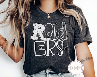May include: A dark grey heather t-shirt with the word "RIDERS" written in white outlined letters. The letters are stylized to look like they were drawn with a marker. There is a small white heart next to the "S".