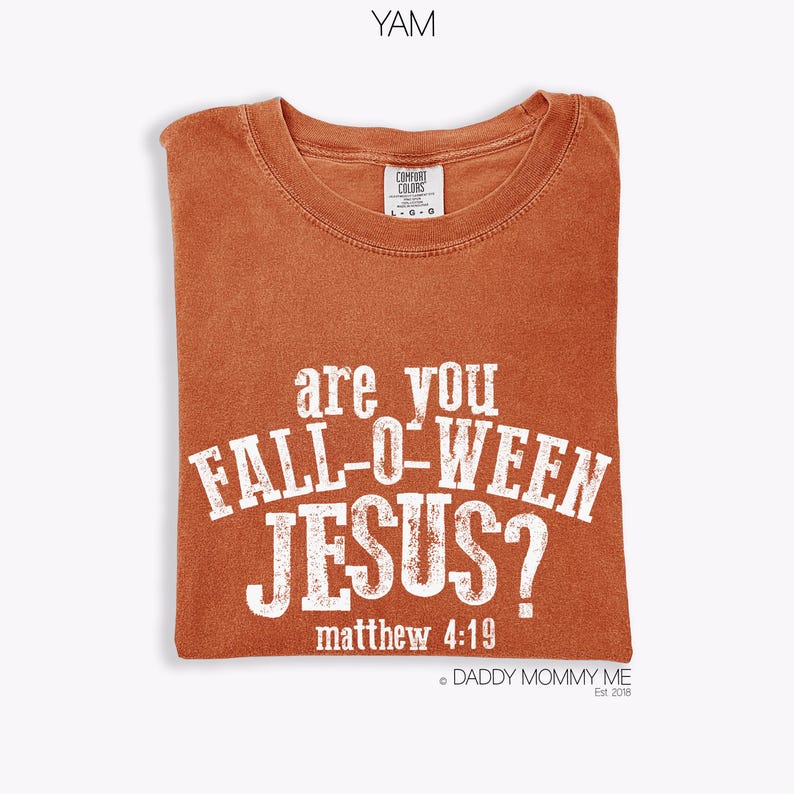 Puede incluir: Una camiseta de cuello redondo color &oacute;xido con letras blancas desgastadas que dicen "are you FALL-O-WEEN JESUS?" seguidas de "matthew 4:19". La camiseta tiene una etiqueta de la marca Comfort Colors en el cuello interior que indica la talla grande.