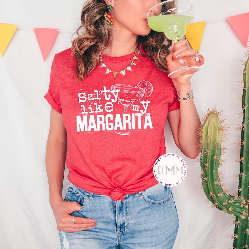 May include: A red t-shirt with the text "Salty like my Margarita" in white lettering. The shirt features a graphic of a margarita glass with a lime wedge.